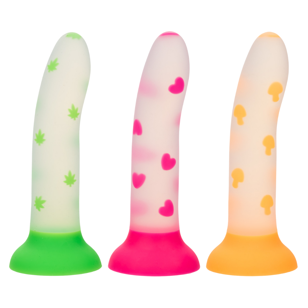 Image of Glow Stick Dildo available in three designs: Pink Hearts, Green Cannabis, and Orange Mushroom, made from body-safe silicone with glow-in-the-dark patterns and a suction cup base.
