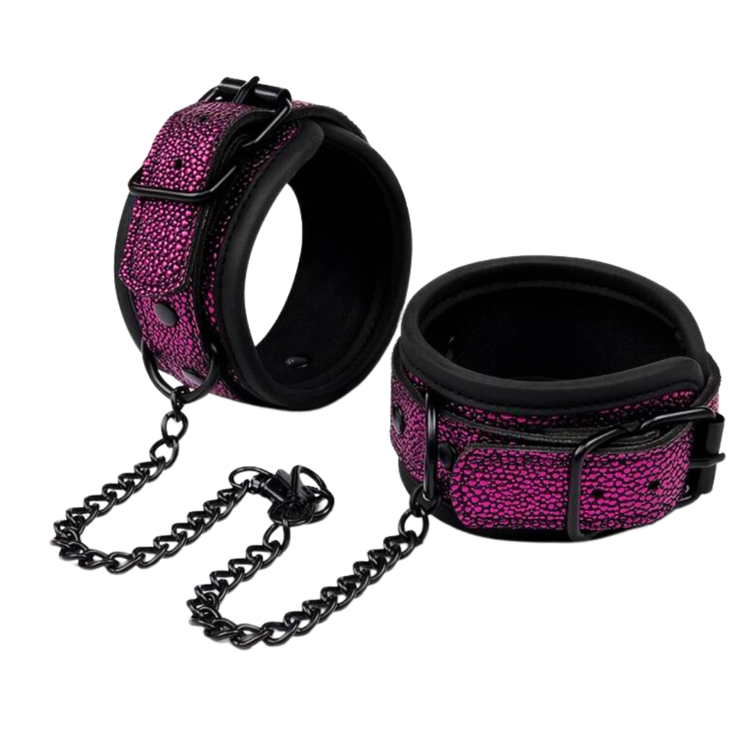 Pink textured bondage cuffs with padded lining and black hardware, designed for comfortable and secure BDSM restraint.