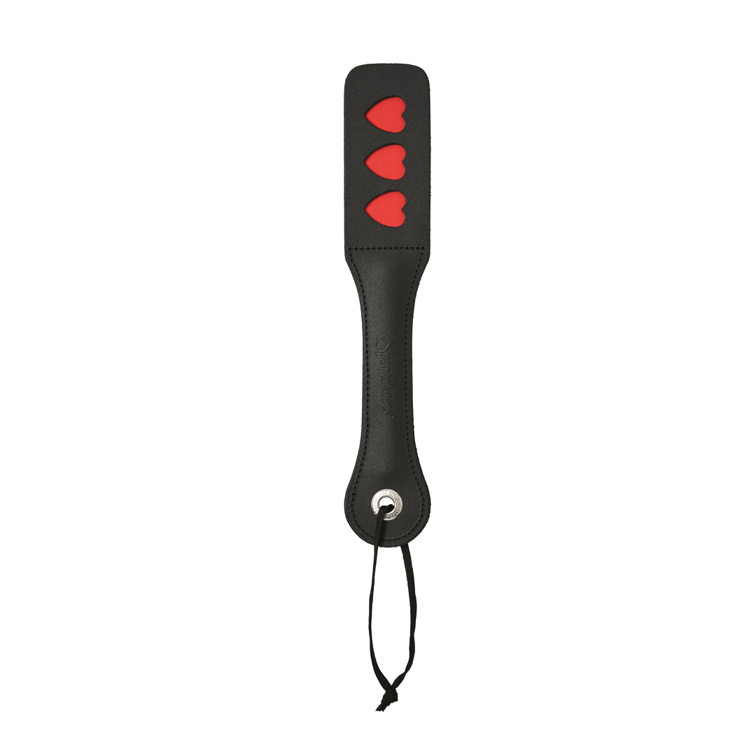 Vegan leather spanking paddle with heart-shaped impressions and a split surface for loud, playful impact.