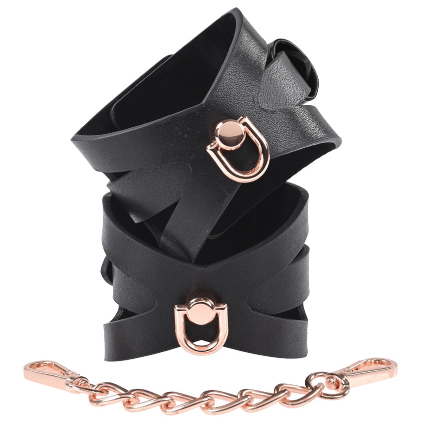 Sportsheets S&M Brat Handcuffs with faux leather design, corset-like cutouts, and rose gold chain for stylish bondage play.
